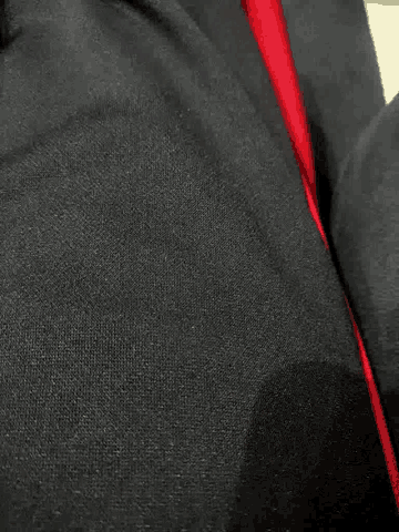 a close up of a black fabric with a red stripe on the bottom