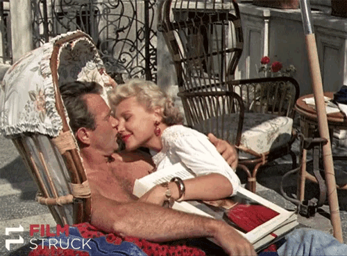 a man and a woman are kissing in a wicker chair with film struck written on the bottom