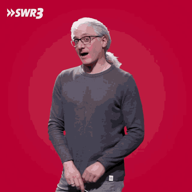 a man is holding a red heart on a stick with swr3 written on the bottom