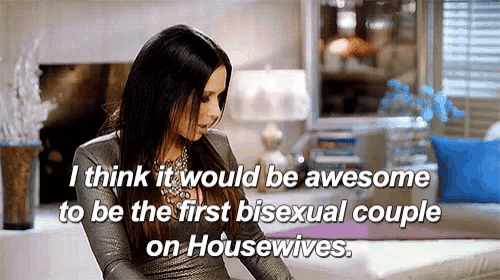 a woman is sitting on a couch and talking about being the first bisexual couple