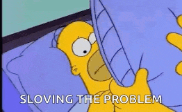 homer simpson from the simpsons is laying in bed with his mouth open and yawning .