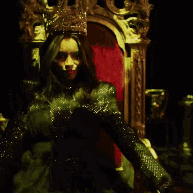a woman in a green dress with a crown on her head