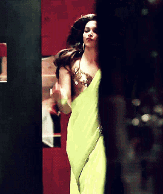 a woman in a yellow dress is standing in a dark room
