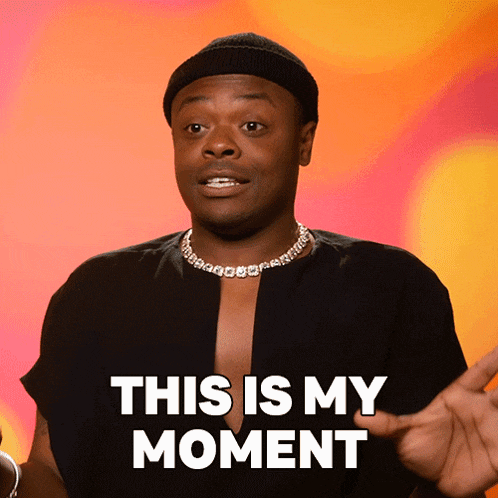 a man wearing a black shirt and a beanie says this is my moment