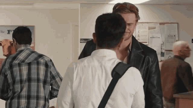 a man in a plaid shirt is standing next to another man