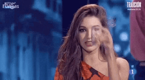 a woman in a red dress is making a funny face on a television screen .