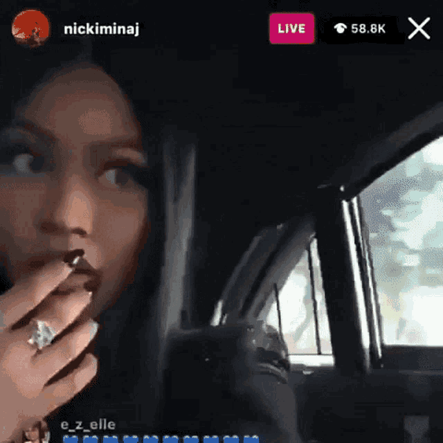 a woman is sitting in the driver 's seat of a car and talking on a live stream .
