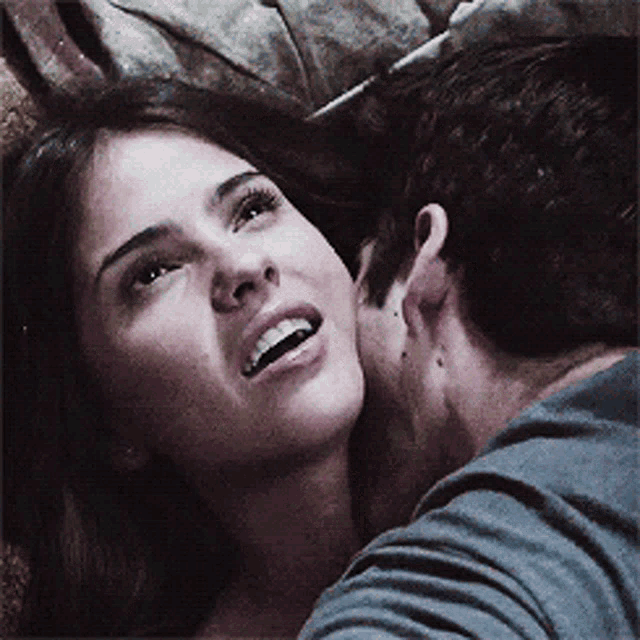 a man is kissing a woman on the cheek and she is smiling .