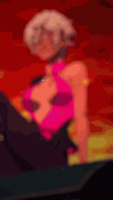 a woman in a pink top and black pants is laying down