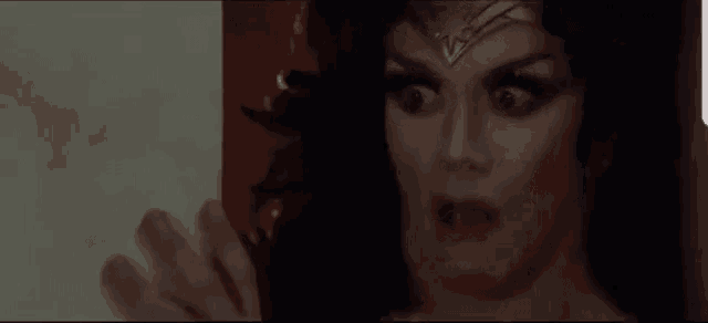 a close up of a woman in a wonder woman costume looking at something .