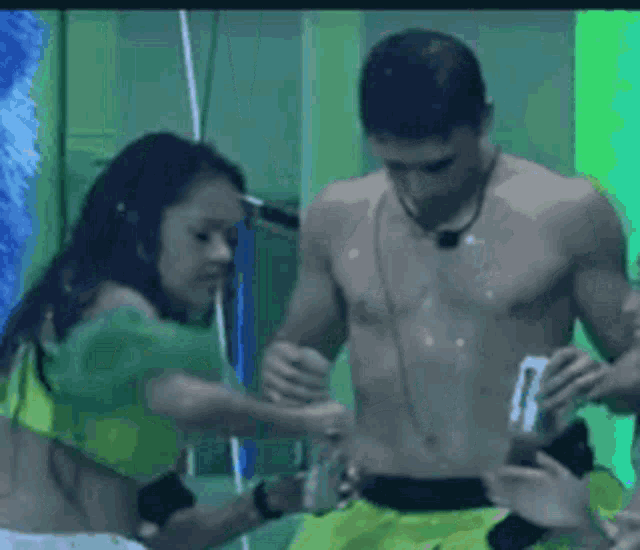 a woman in a green top is standing next to a man in green shorts .