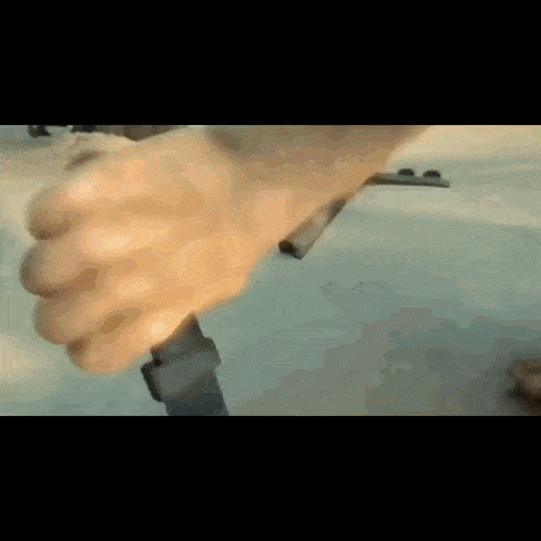 a close up of a person 's hand holding a black object