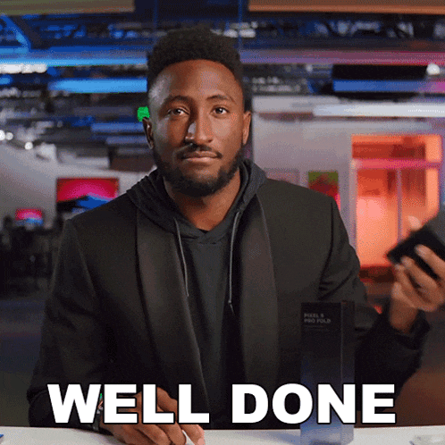 a man in a tuxedo says well done while holding a phone