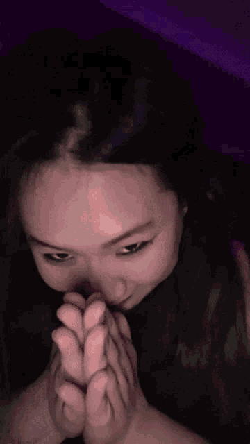 a close up of a woman 's face with her hands on her face