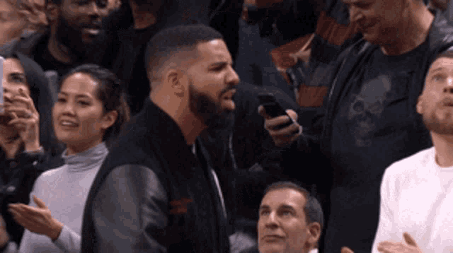 a man with a beard is holding a cell phone in his hand