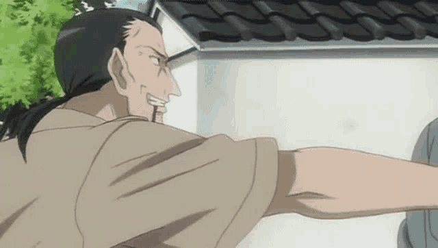 a man in a brown shirt is pointing at another man in front of a white building .