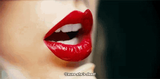 a close up of a woman 's lips with red lipstick and a phrase .