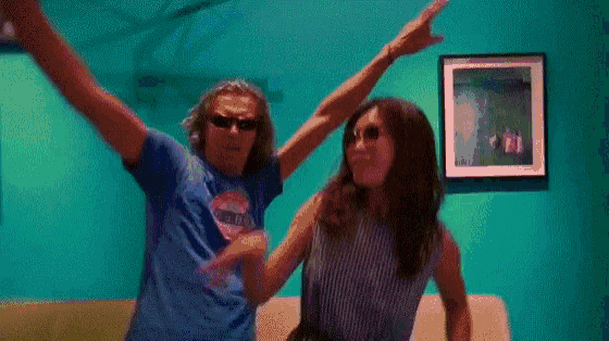 a man and a woman are dancing together in front of a picture on the wall .