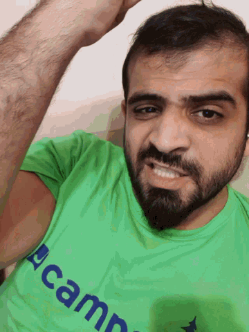 a man with a beard is wearing a green shirt that says camp on it