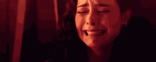 a woman is crying in a dark room while holding a baby .