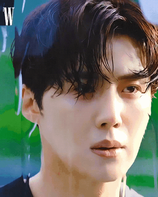 a close up of a young man 's face with the letter w in the corner
