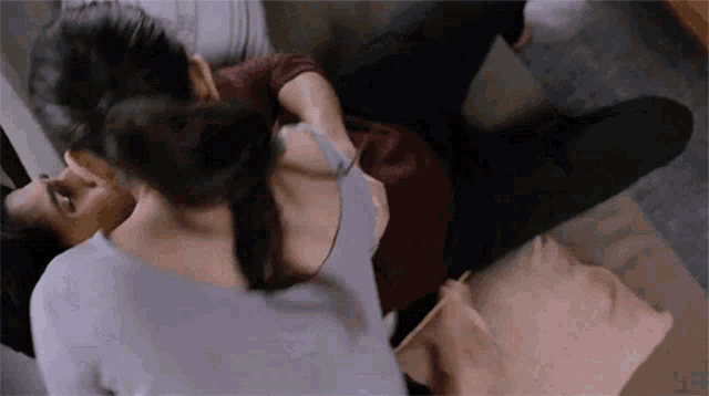 a man and a woman are kissing on a couch .