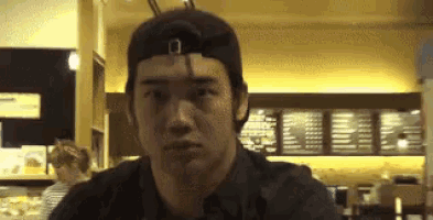 a man wearing a hat is looking at the camera in a store .