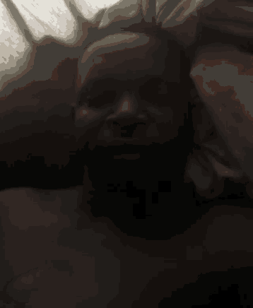 a man without a shirt is laying in bed