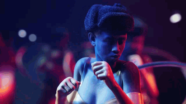 a woman with blue paint on her body is dancing