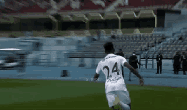 a soccer player with the number 24 on his back is running on the field