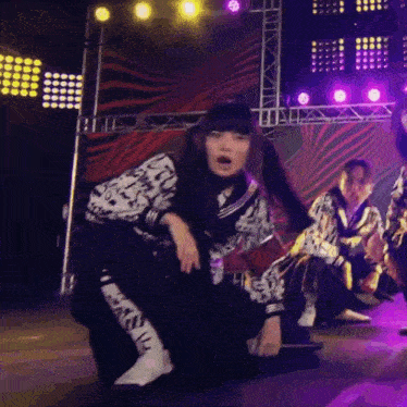 a group of people are performing on a stage and one of them is wearing a shirt that says ' i am '