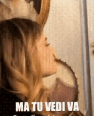 a woman with horns on her head is looking at herself in a mirror and saying `` ma tu vediva '' .