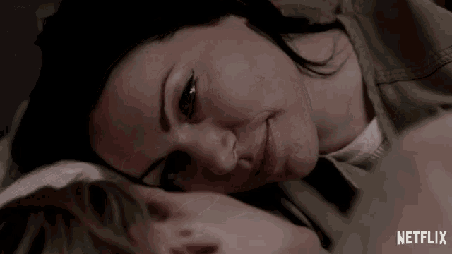 a close up of a woman laying next to a man with the word netflix on the bottom right