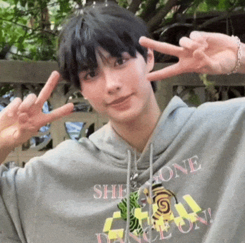 a young man wearing a hoodie that says she gone dance on is giving a peace sign
