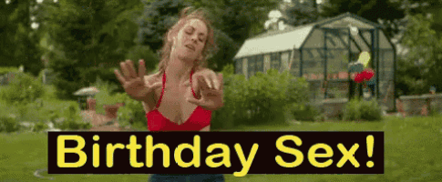 a woman in a red bikini is standing in the grass with a sign that says birthday sex ..