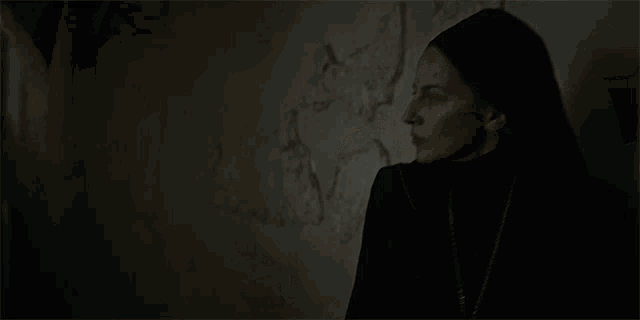a nun in a dark room with the words en garde in latin on the bottom
