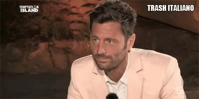 a man with a beard is wearing a pink suit and sunglasses .