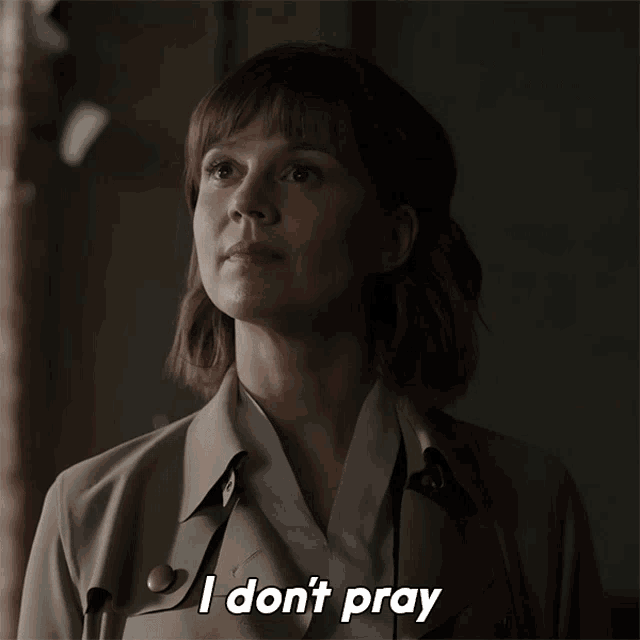 a woman in a trench coat says " i don t pray "
