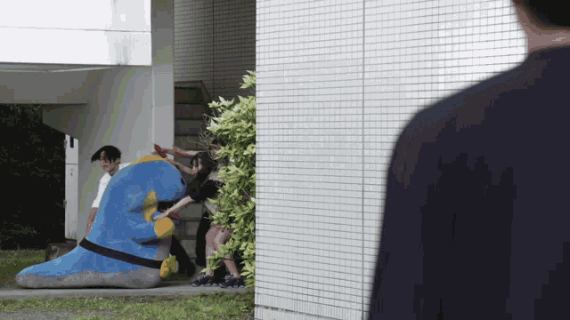 a man in a black shirt is standing in front of a building