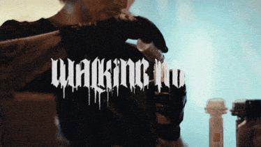 a man is holding a bottle with the word walking in the background