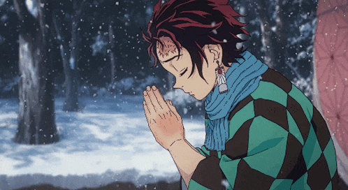 a man with a scarf around his neck prays in the snow