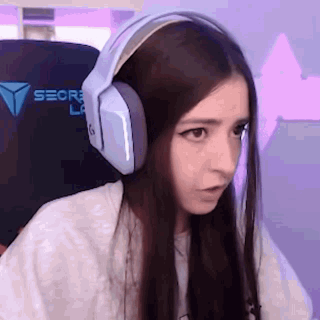 a woman wearing headphones is sitting in a chair that says seore