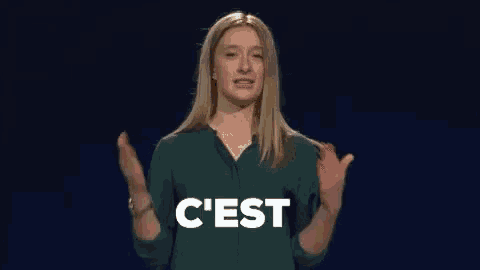 a woman in a green shirt is clapping her hands in front of the word vraiment