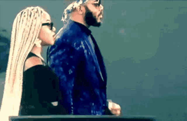 a man and a woman standing next to each other in a dark room