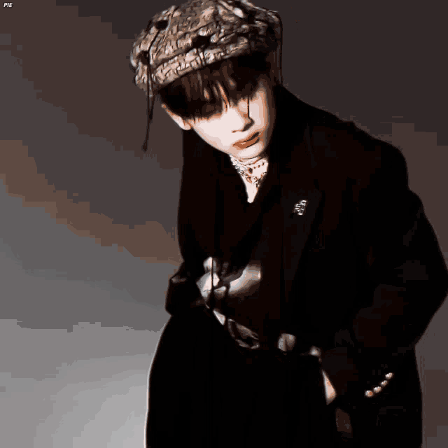 a man wearing a hat and a black jacket has the word pie on the bottom right
