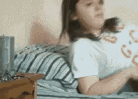 a girl is laying on a bed wearing a white shirt with the word gucci on it .