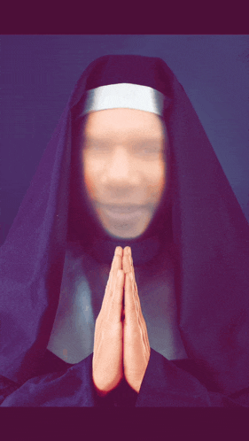 a blurred image of a nun praying with her hands folded