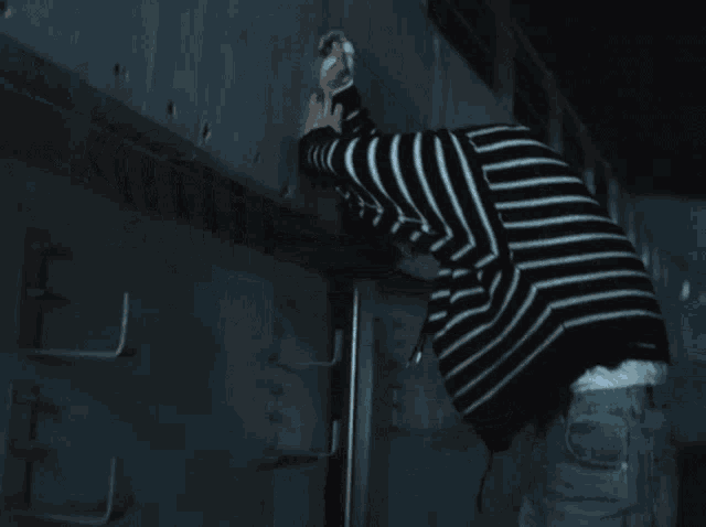 a man wearing a black and white striped sweater with a hood