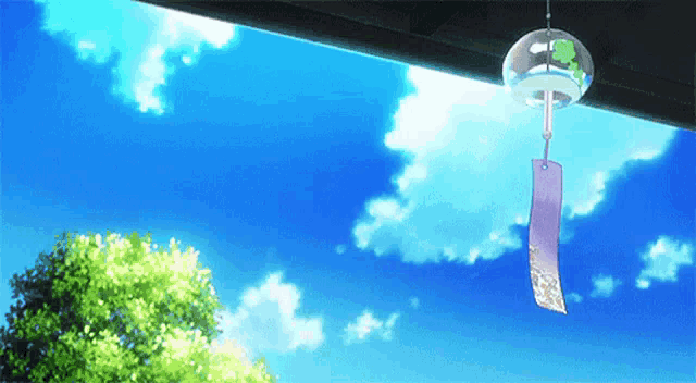 a wind chime is hanging from the roof of a building in front of a blue sky .