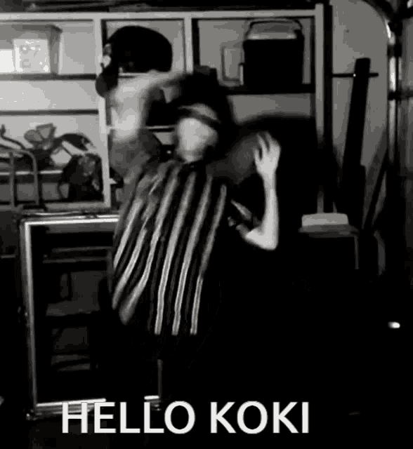 a black and white photo of a person dancing with the words hello koki written on the bottom .